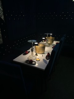 Table with hookah setup, drinks, and candles at Moustache Lounge