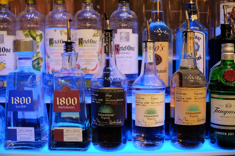 Backlit liquor bottles on display at Moustache Hookah Lounge bar